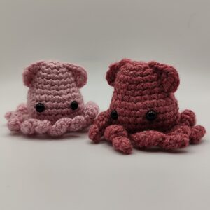 Deux peluches calamars rose clair et rose foncé sur fond blanc