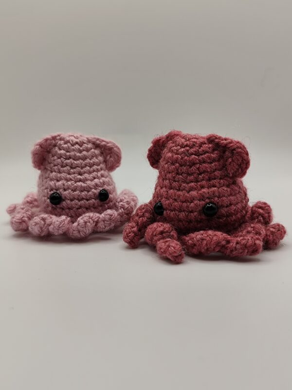 Deux peluches calamars rose clair et rose foncé sur fond blanc