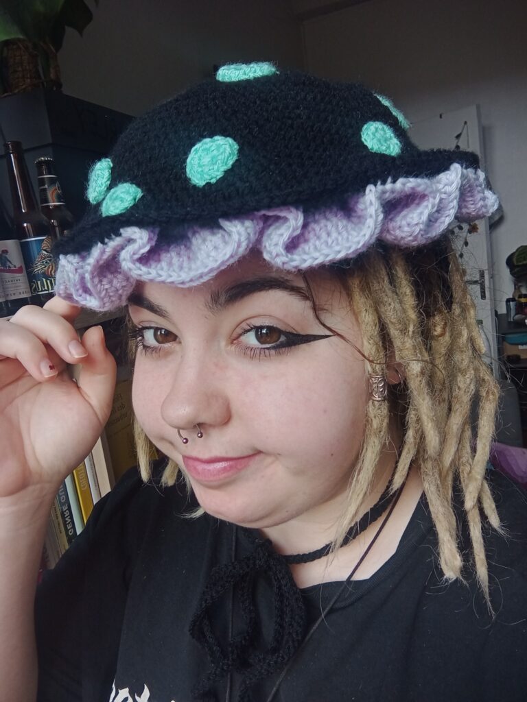 Ewen portant sa création personalisée chapeau champignon en crochet fait-main