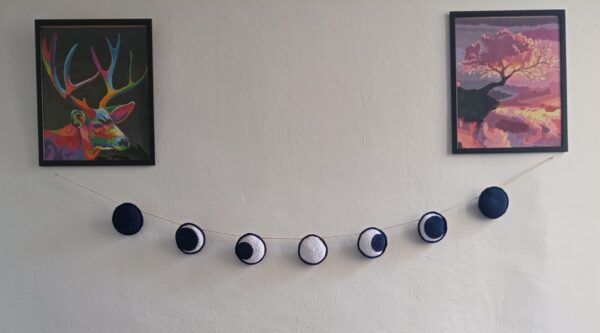 guirlande lune en crochet sur un mur blanc