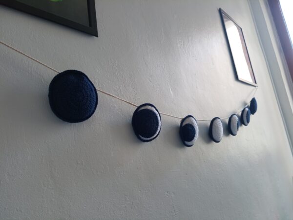 guirlande lune en crochet sur un mur blanc