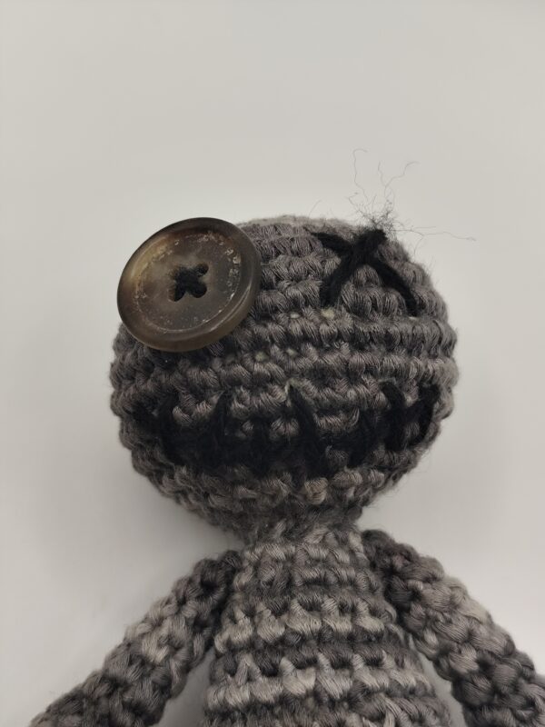 peluche poupée voodoo au crochet sur fond blanc, détail de la tête